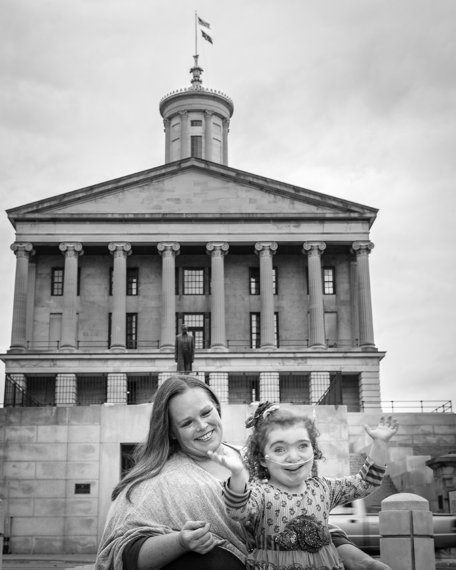 Black and White photo of young woman with her daughter posing in front of a colonial-style capitol building.
