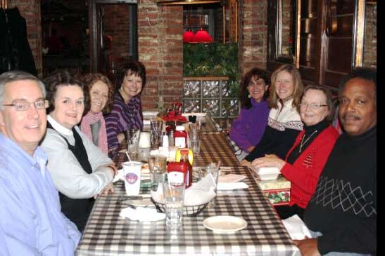 Photo of David Welch, Pam Munz, Faye Jones, Valerie Belew, Eileen Crane, Jennifer Knapp, Ellen Weed, and Ted Washington at a deans’ holiday luncheon at Calhoun’s.